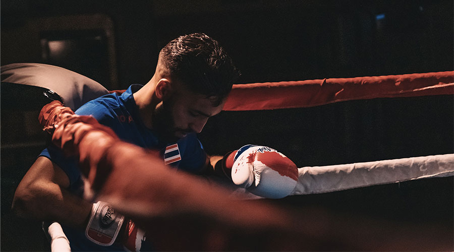 A picture of a boxer resting in the corner of the ring. Important to note your purpose in our Winning Training Boxing Gloves review.